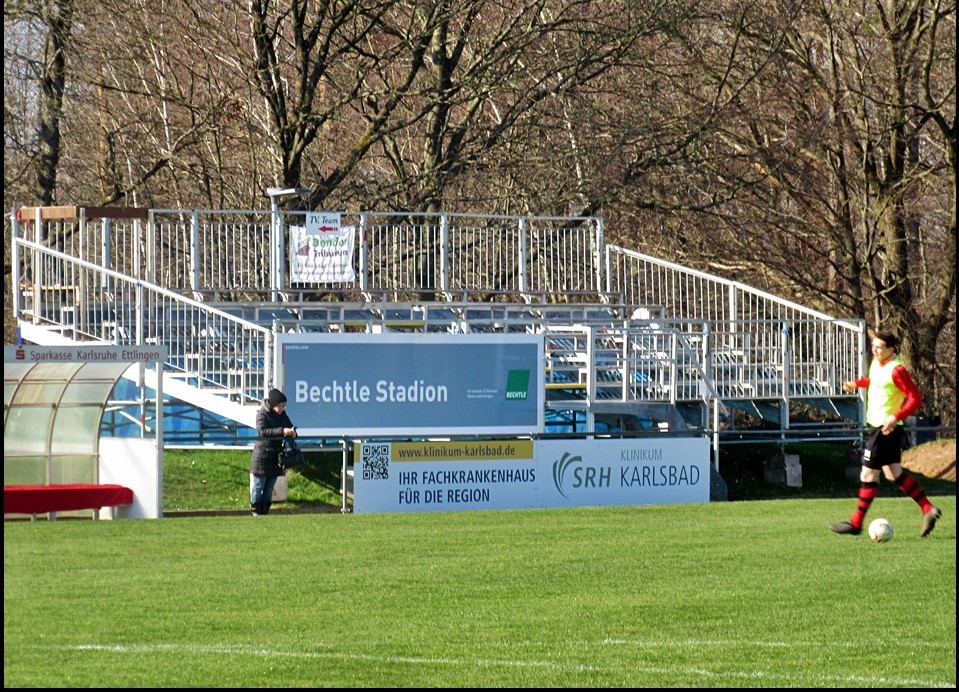 Tribüne am Spielfeldrand mit Rasen